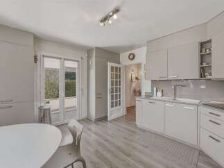 Discover this modern kitchen featuring sleek, light gray cabinetry and a spacious countertop.