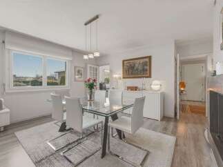 Bright and airy dining room featuring a sleek glass-top dining table with modern white chairs, perfect for intimate gatherings.