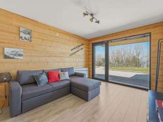 Experience modern living in this beautifully appointed room featuring a comfortable sectional sofa and large sliding glass doors that open to a scenic view.