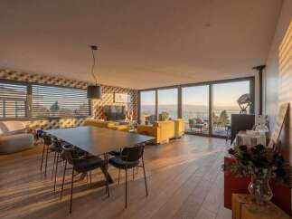 Experience breathtaking sunset views from this modern living and dining area, featuring a stylish geometric wallpaper and comfortable yellow sofas.