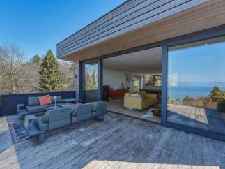 Experience modern living with this stunning property featuring a spacious outdoor deck perfect for entertaining and enjoying breathtaking water views.