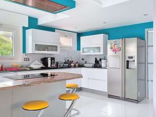 Experience modern living in this stunning kitchen, featuring sleek white cabinetry and vibrant turquoise walls.