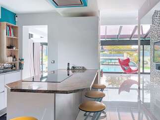This modern kitchen features a sleek white island with a granite countertop, perfect for casual dining or entertaining.