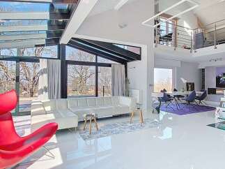 Experience modern luxury in this stunning open-concept living space, featuring a dramatic glass ceiling and walls that flood the interior with natural light.