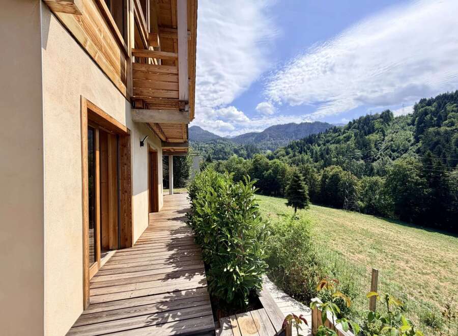 Experience breathtaking mountain views from this stunning property, featuring a spacious wooden deck perfect for outdoor living.