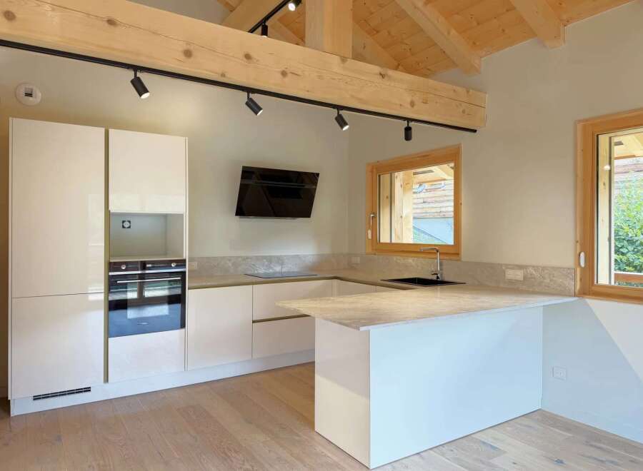 Discover this modern kitchen featuring sleek white cabinetry and integrated appliances, perfect for a contemporary home.