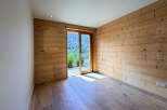 Experience rustic charm and modern comfort in this beautifully appointed room featuring natural wood paneling and a sleek, minimalist design.