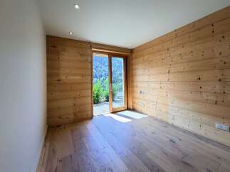Experience rustic charm and modern comfort in this beautifully appointed room featuring natural wood paneling and a sleek, minimalist design.