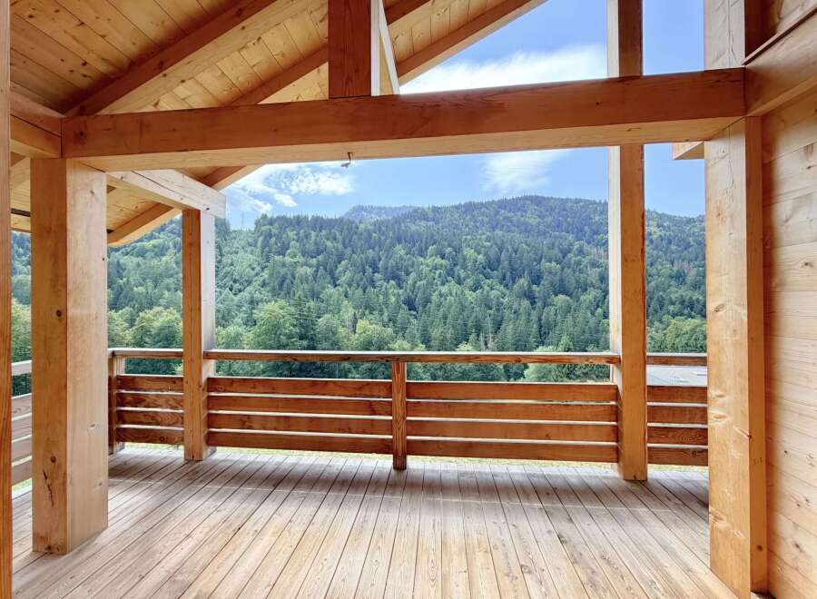 Experience breathtaking mountain views from this stunning wooden deck, perfect for enjoying the serene natural surroundings.