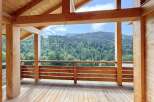 Experience breathtaking mountain views from this stunning wooden deck, perfect for enjoying the serene natural surroundings.