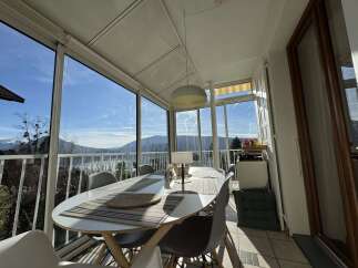 Enjoy breathtaking mountain and lake views from this sun-drenched dining room, enclosed by expansive windows.