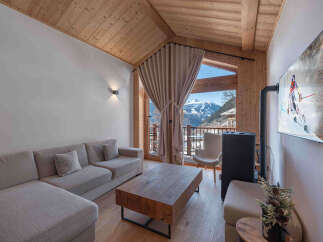 Experience luxury mountain living in this stunning alpine retreat, featuring a spacious sectional sofa and a rustic wooden coffee table perfect for cozy evenings.