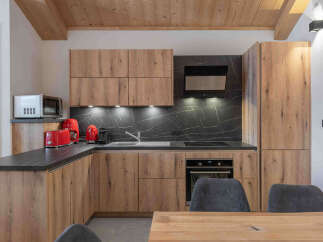 Experience modern living in this beautifully appointed kitchen, featuring sleek wooden cabinetry and a striking black marble backsplash.