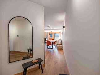 Step into this inviting entryway featuring a large arched mirror and a sleek black bench, perfect for a quick touch-up before heading out.