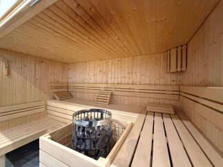 Experience ultimate relaxation in this luxurious wooden sauna, featuring multiple tiered benches for comfortable seating.