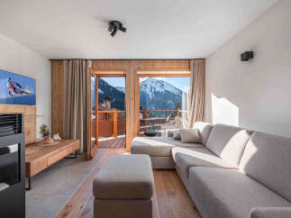 Experience breathtaking mountain views from this stunning living room, featuring a comfortable sectional sofa and a modern entertainment center.
