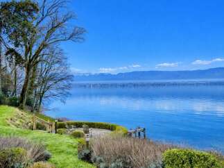 Experience breathtaking lakefront living with this stunning property offering panoramic views of the water and distant mountains.
