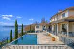Experience luxurious lakeside living in this stunning property, featuring an infinity pool that seamlessly blends with the serene blue waters.