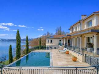 Experience luxurious lakeside living in this stunning property, featuring an infinity pool that seamlessly blends with the serene blue waters.