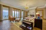 Experience luxurious living in this elegant living room, featuring a grand fireplace and expansive glass doors that open to breathtaking water views.