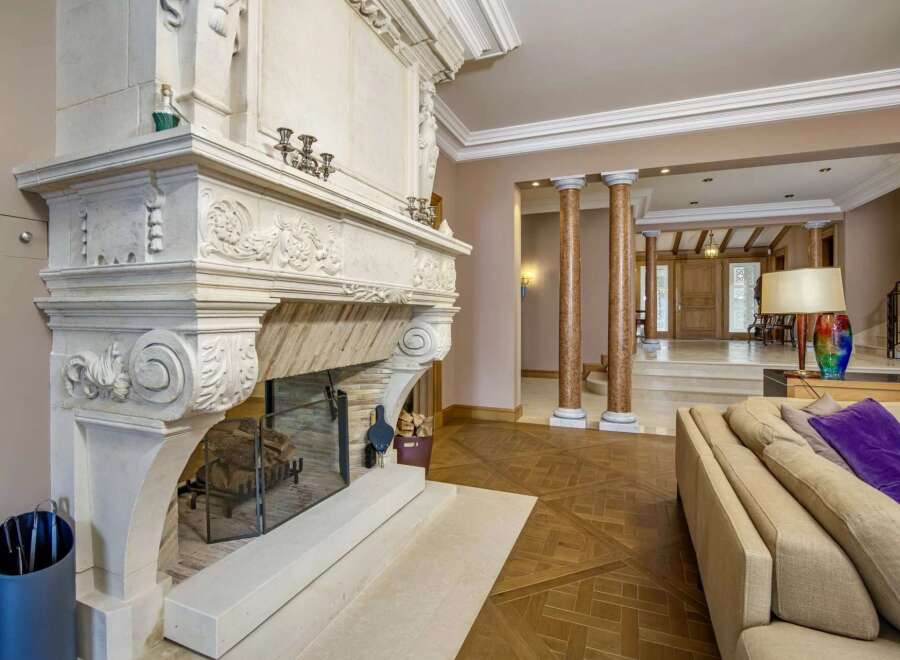 Experience opulent living in this grand foyer, featuring a magnificent ornate fireplace as the centerpiece.