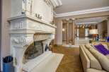 Experience opulent living in this grand foyer, featuring a magnificent ornate fireplace as the centerpiece.