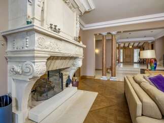 Experience opulent living in this grand foyer, featuring a magnificent ornate fireplace as the centerpiece.