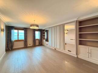 Experience luxury living in this spacious room featuring elegant floor-to-ceiling mirrored wardrobes and built-in shelving.