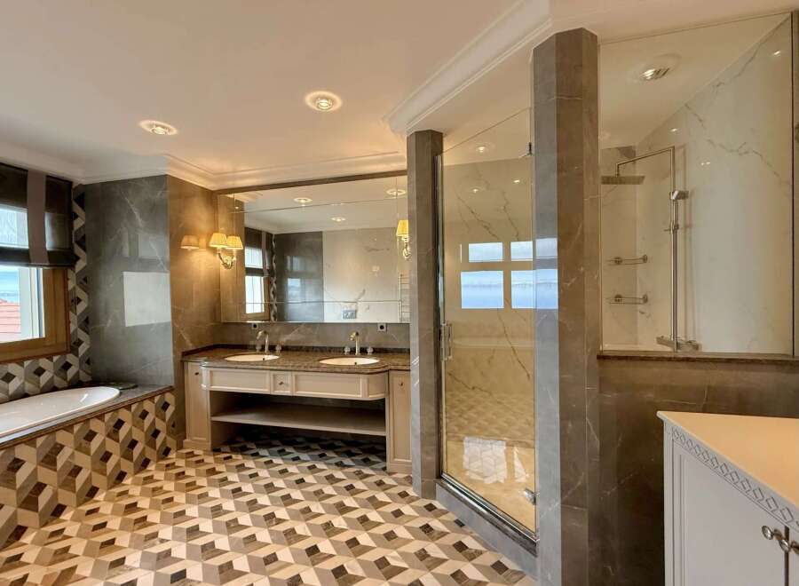 Experience luxury in this stunning bathroom featuring a spacious soaking tub and a separate glass-enclosed shower.