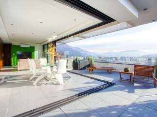 Experience luxurious indoor-outdoor living with this stunning penthouse featuring a spacious balcony overlooking breathtaking mountain views.