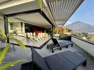 Experience luxurious indoor-outdoor living with this stunning property featuring a spacious terrace overlooking a picturesque mountain landscape.
