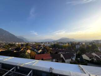 Experience breathtaking panoramic views from this elevated property, overlooking a charming town nestled against majestic mountains.