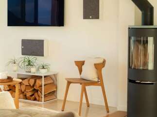 Experience modern living in this stylish room featuring a sleek wall-mounted television and integrated sound system.