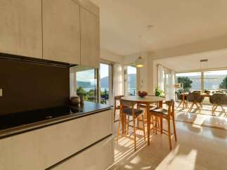 Experience modern living in this stunning home featuring a sleek kitchen with a built-in stovetop and ample cabinet space.