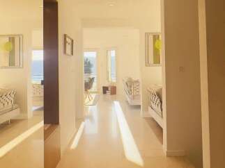 Sunlight streams into this modern hallway, illuminating the polished floors and elegant decor.