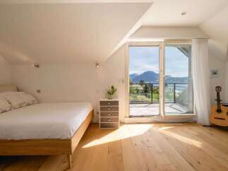 Experience breathtaking mountain and lake views from this charming attic bedroom.