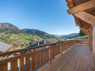 Experience breathtaking mountain views from this stunning wooden balcony, perfect for enjoying your morning coffee or evening relaxation.