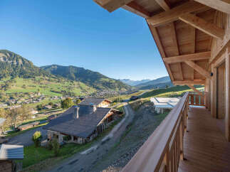 Experience breathtaking mountain views from this stunning property, featuring a spacious wooden balcony perfect for enjoying the serene landscape.