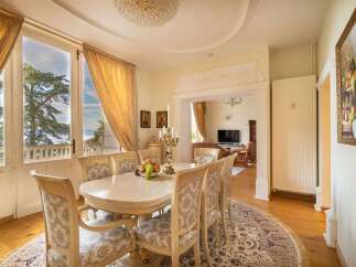 Experience elegant dining with this exquisite formal dining room, featuring a stunning marble-top table and plush upholstered chairs.