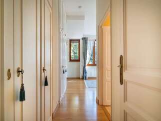 Step into this charming hallway featuring elegant built-in wardrobes with decorative tassels and brass hardware.
