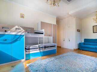 This spacious room features a vibrant blue bunk bed with ample storage, perfect for a child's room or guest accommodation.