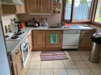 This charming kitchen features light wood cabinetry and a functional layout, perfect for any home chef.