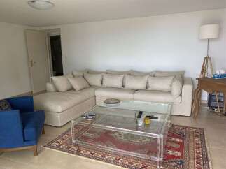 Experience modern living in this spacious living room, featuring a comfortable sectional sofa and a stylish acrylic coffee table.