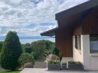 Enjoy breathtaking lake views from this charming property, nestled amidst lush greenery and mature trees.