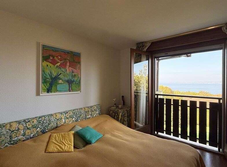 Experience breathtaking ocean views from this charming bedroom, featuring a comfortable bed with a floral headboard and direct access to a private balcony.