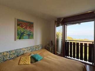 Experience breathtaking ocean views from this charming bedroom, featuring a comfortable bed with a floral headboard and direct access to a private balcony.