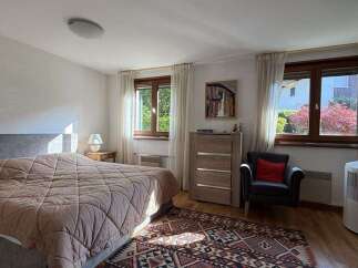 This inviting bedroom features a comfortable bed with a plush comforter, perfect for relaxation.