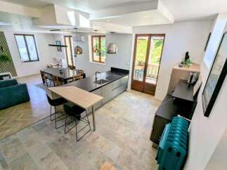 This spacious open-plan living area features a modern kitchen island with bar seating, perfect for casual dining.