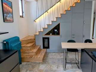 Discover modern living with this stunning kitchen and dining area, featuring a unique under-stair wine cooler and coffee station.
