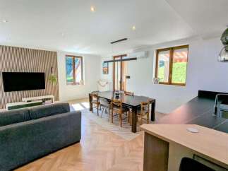 This spacious open-plan living and dining area features a modern dark wood dining table with chairs, perfect for family meals.